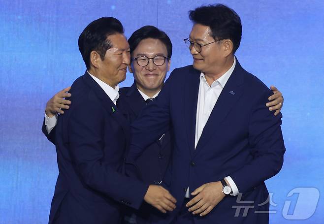 더불어민주당 김민석 신임 당대표가 17일 대전시 유성구 대전컨벤션센터에서 열린 더불어민주당 제3차 정기전국당원대회에서 정청래, 송영길 후보의 등을 토닥이고 있다. (공동취재) 2026.8.17 ⓒ 뉴스1 황기선 기자